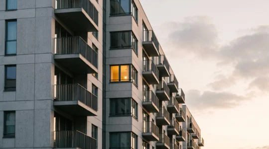 Facade d'un immeuble residentiel contemporain au lever du jour, symbolisant la duree d'engagement locatif de neuf ans du dispositif Pinel